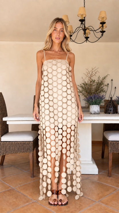 Front view of woman wearing beige cream circle cutout maxi dress