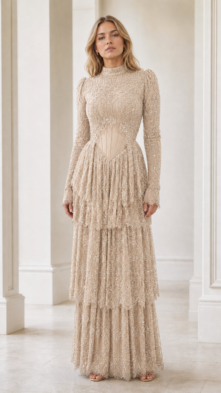 Model wearing champagne beige long sleeve beaded tiered formal gown