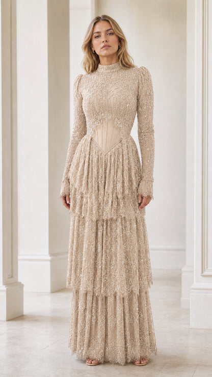 Model wearing champagne beige long sleeve beaded tiered formal gown